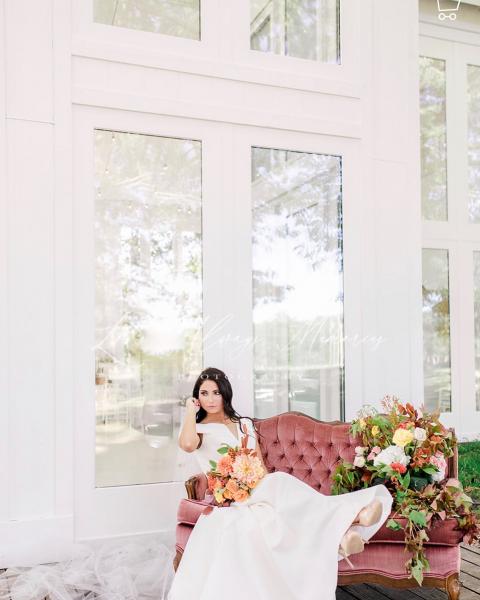 Bride on pink couch outside of wedding venue