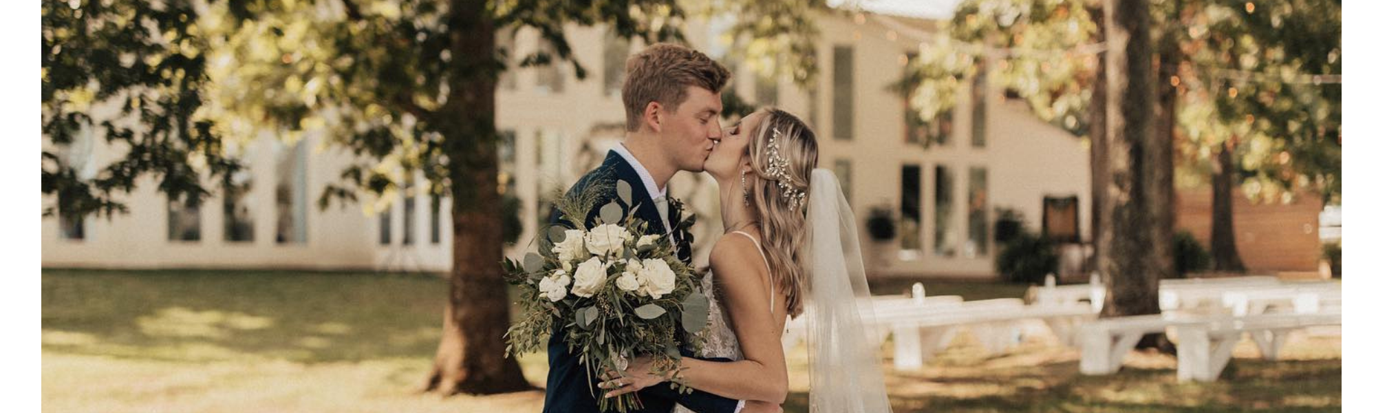 bride and groom kissing outside of wedding venue